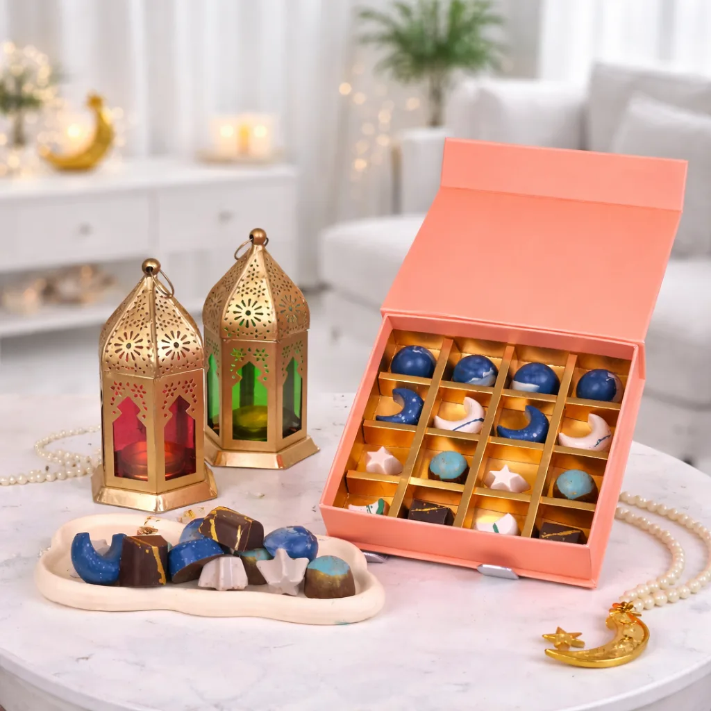 A white crescent moon-shaped floral stand featuring peach spray roses, blue hydrangeas, and silver brunia berries, styled on a table with a gold Ramadan lantern and prayer beads.