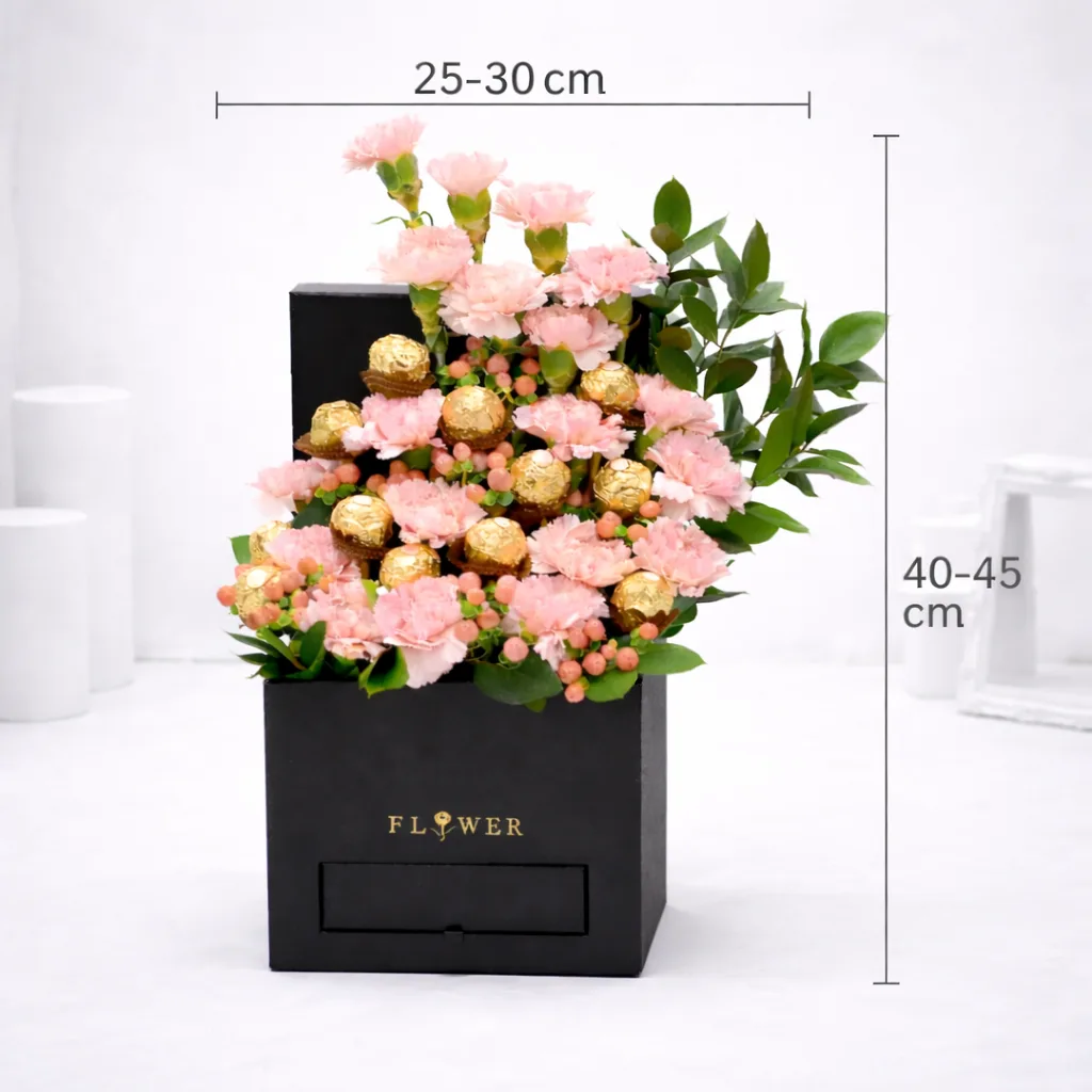 `Pink carnations and Ferrero Rocher chocolates in a black gift box, measuring 25–30 cm wide and 40–45 cm tall.`