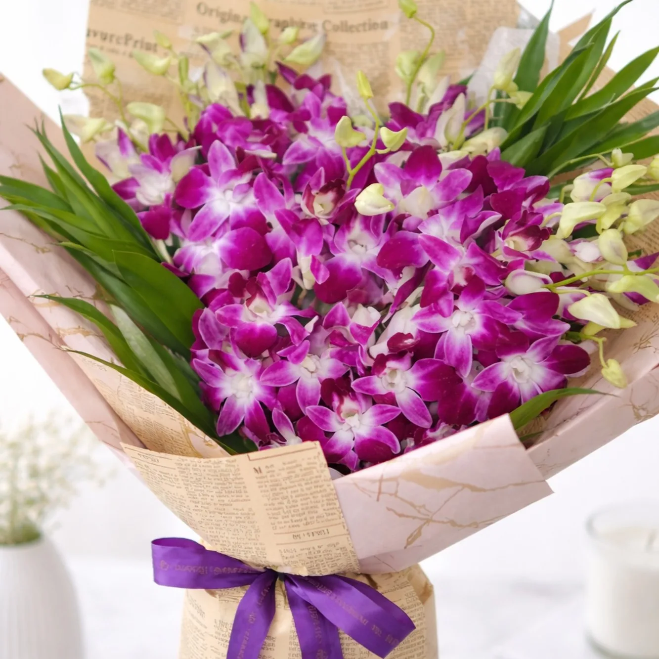 Close-up of a purple dendrobium orchid bouquet in newspaper print wrapping with a purple ribbon