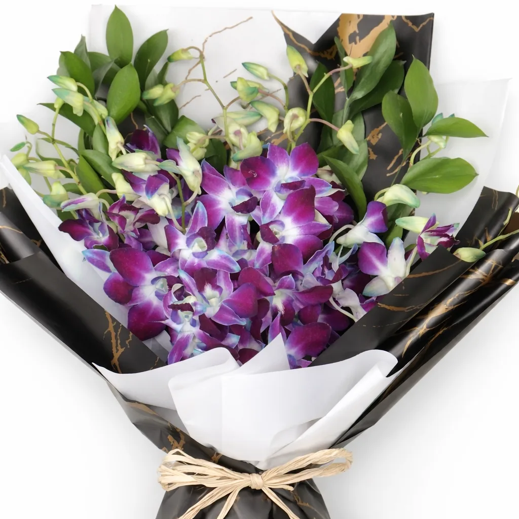 Close-up of purple dendrobium orchids in black marble and white wrapping.