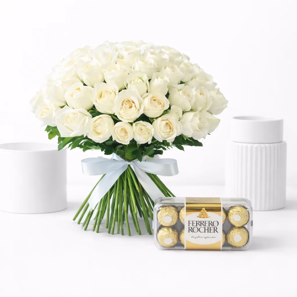 White rose bouquet with a blue ribbon next to a box of Ferrero Rocher chocolates.