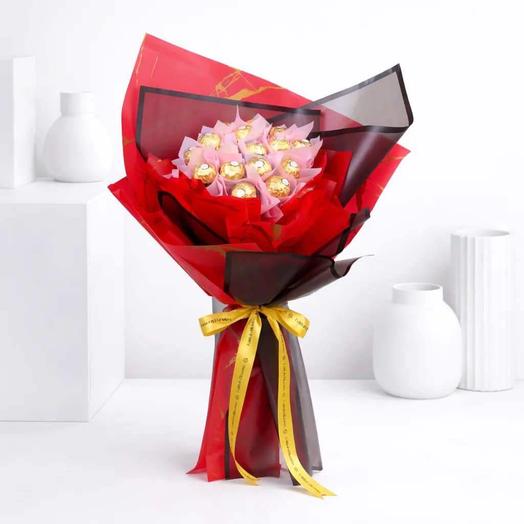 Ferrero Rocher chocolate bouquet wrapped in red and black paper with a gold ribbon bow.