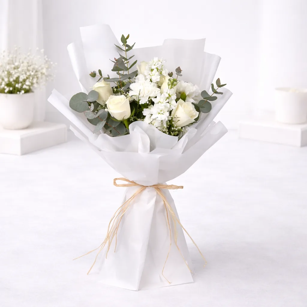 White Rose and Eucalyptus Bouquet wrapped in white paper with raffia bow