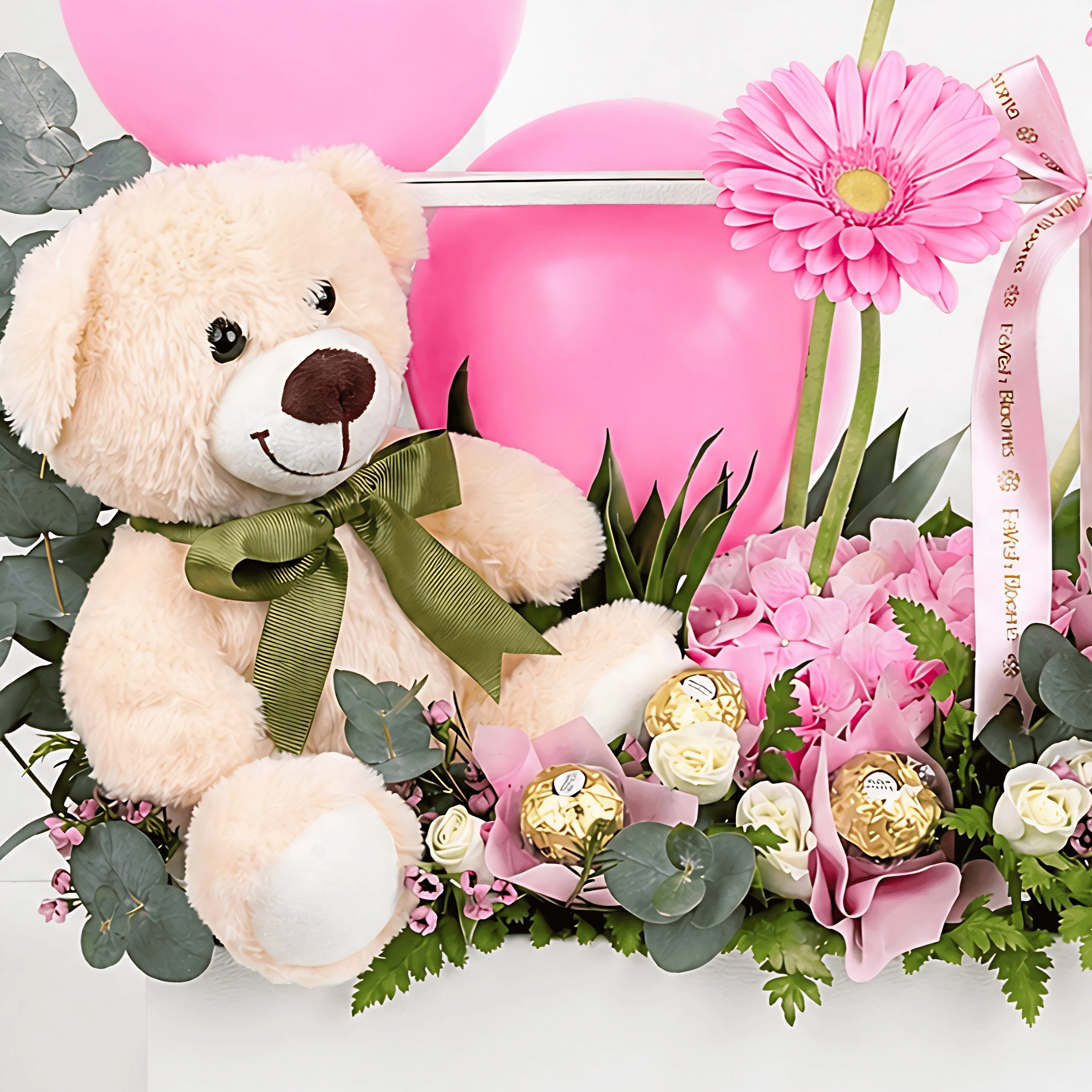 Close-up pink gift arrangement with teddy bear, pink balloons, gerbera flowers, Ferrero Rocher chocolates, eucalyptus, and fresh greenery.