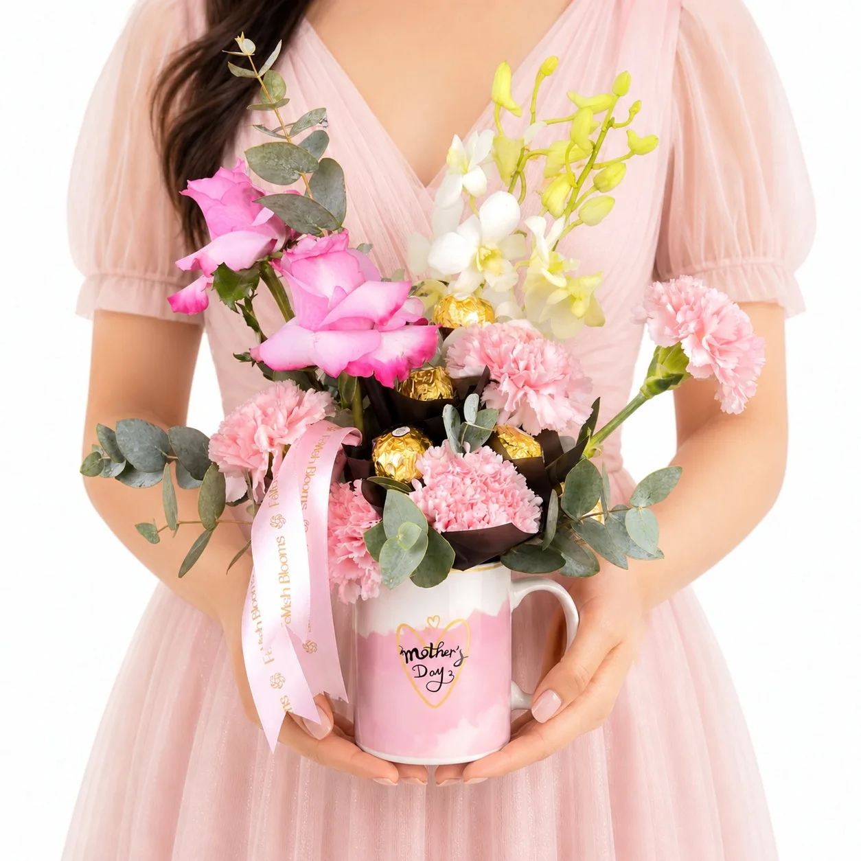 Hand holding pink floral mug arrangement with mixed flowers.