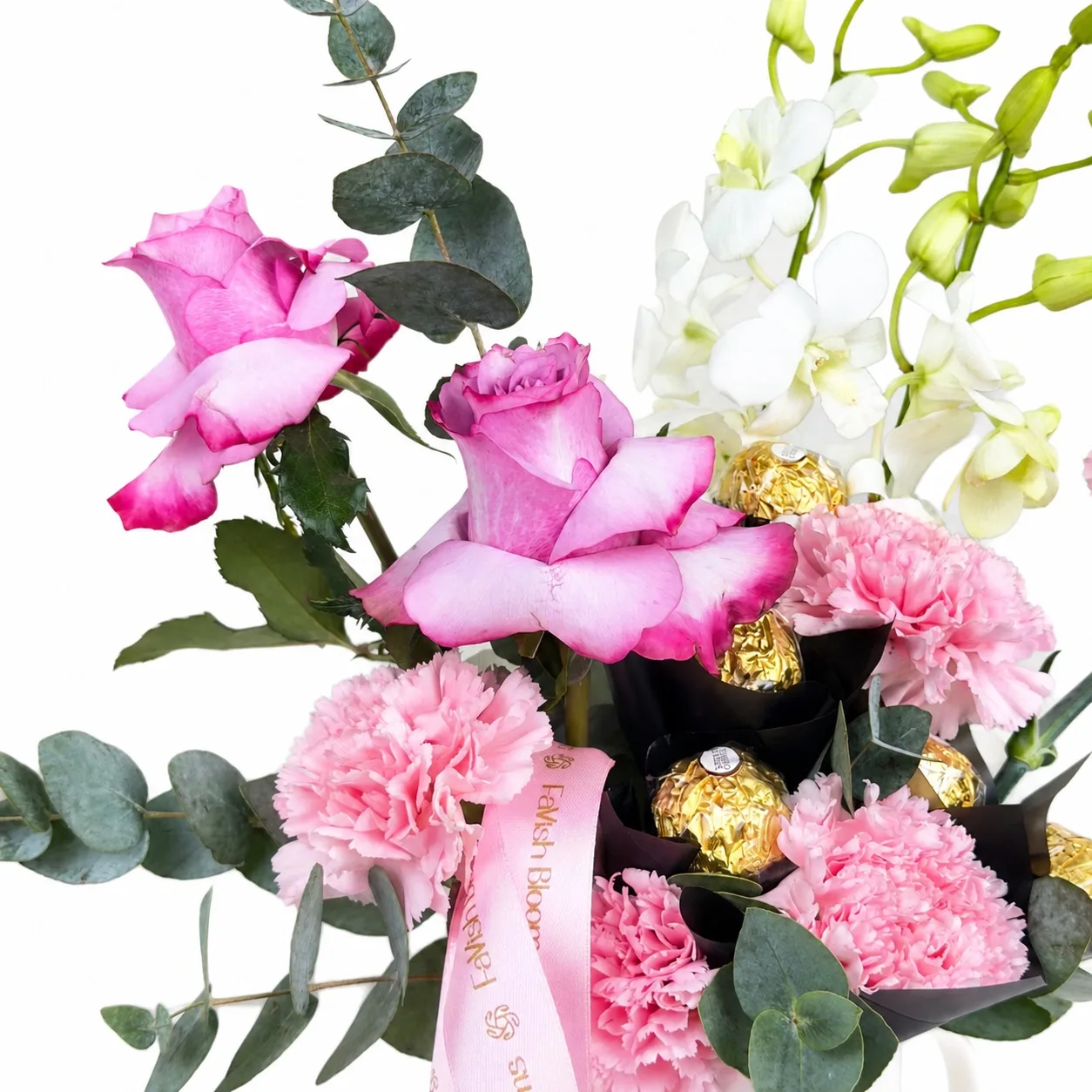 Pink rose, orchid, carnation, eucalyptus, and chocolate mug arrangement.