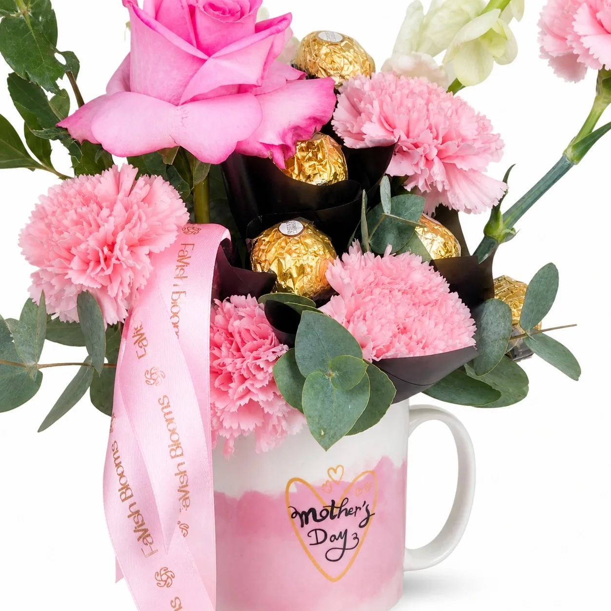Pink mug arrangement with roses, carnations, orchids, eucalyptus, and chocolates.