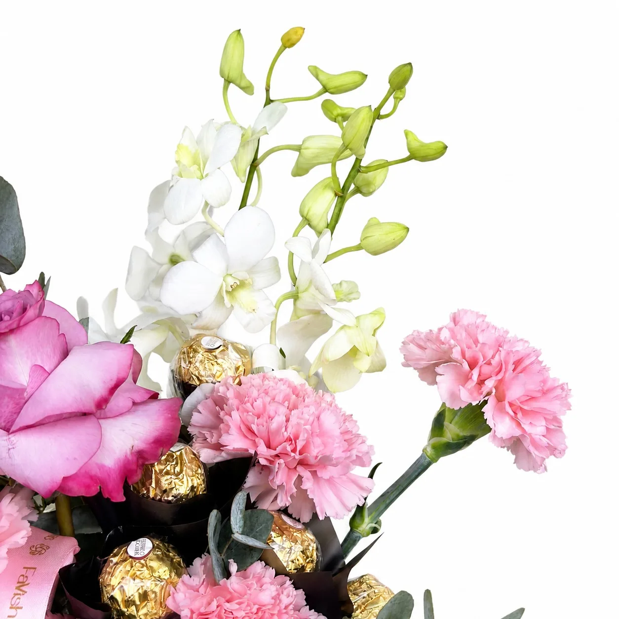 Mixed pink flowers and Ferrero Rocher chocolates in a pink mug.