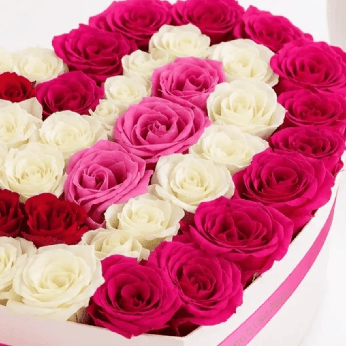 Close-up of a luxury heart-shaped rose arrangement featuring red, white, and pink roses in a premium floral gift box