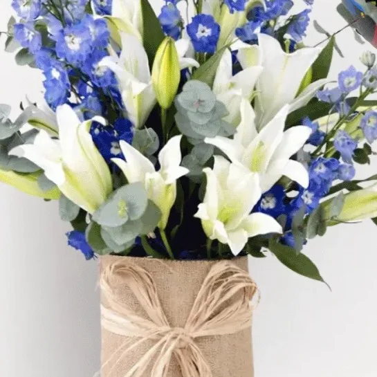 Elegant Father’s Day flower vase with blue delphinium, white lilies, and dad balloons