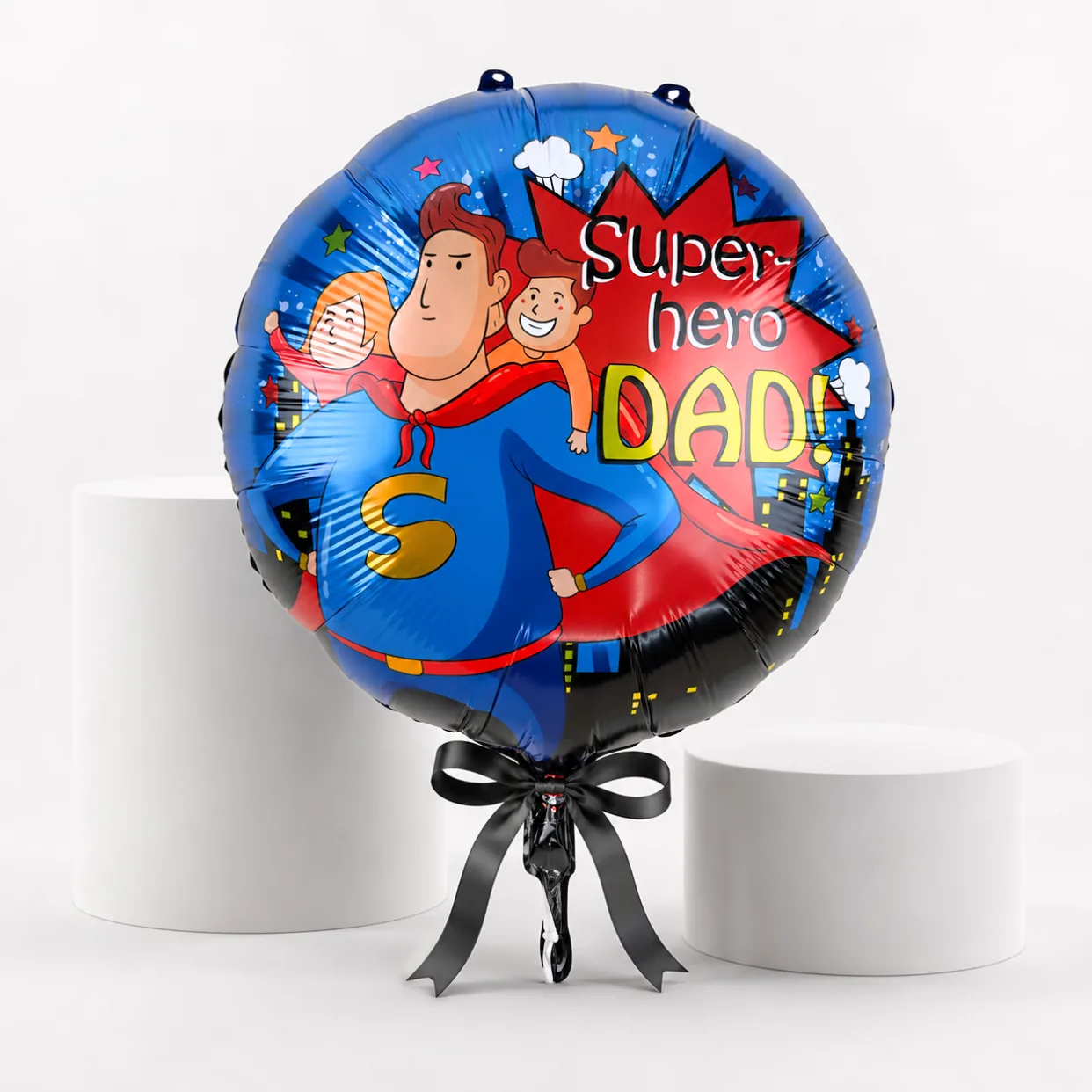 Superhero Dad helium foil balloon with black ribbon on a white display setup for Father’s Day.
