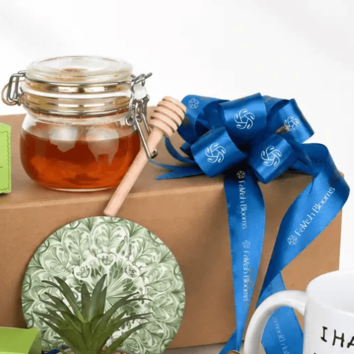Close-up of Father’s Day gift hamper with honey jar, blue FaVish Blooms ribbon, mini plant and Dad mug.