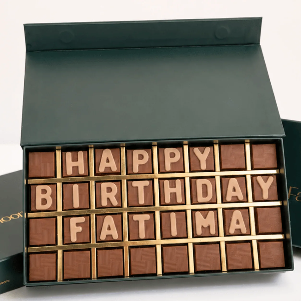 "Close-up of chocolate letter box spelling 'Happy Birthday Fatima' in a green FaVish Blooms gift box."