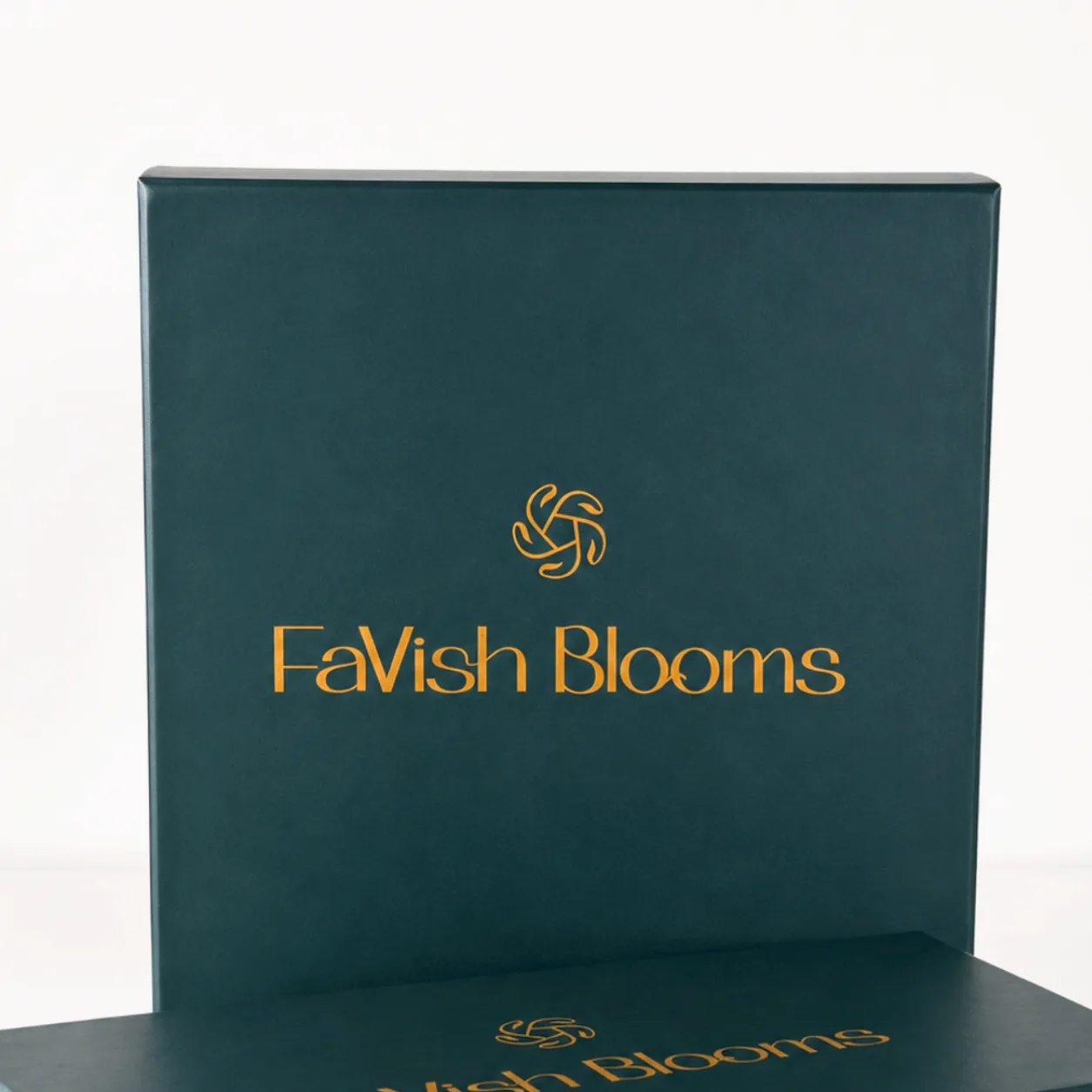 "Close-up of dark green FaVish Blooms gift box lid with gold logo and lettering."
