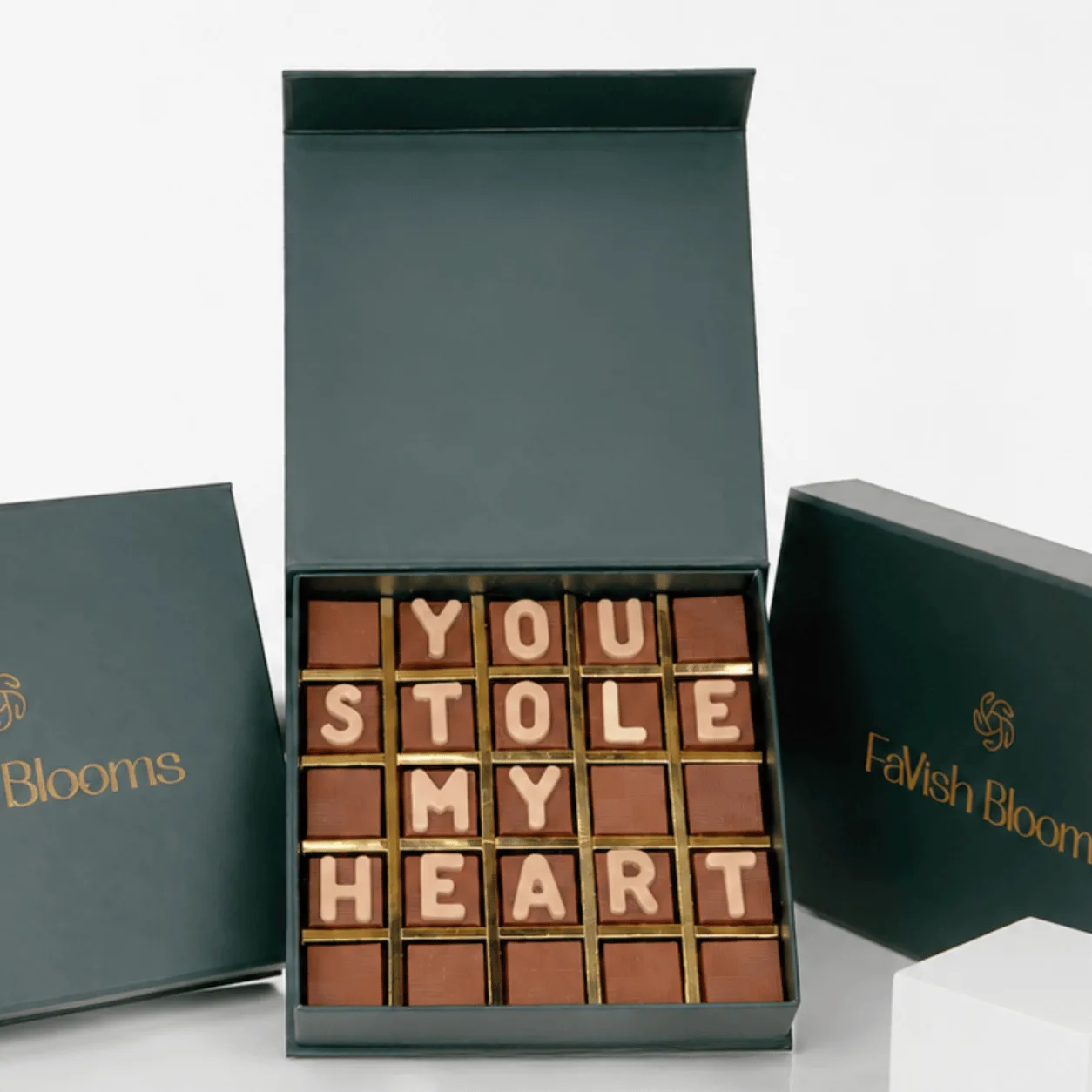 "Close-up of chocolate letter box spelling 'You Stole My Heart' in a green FaVish Blooms gift box."