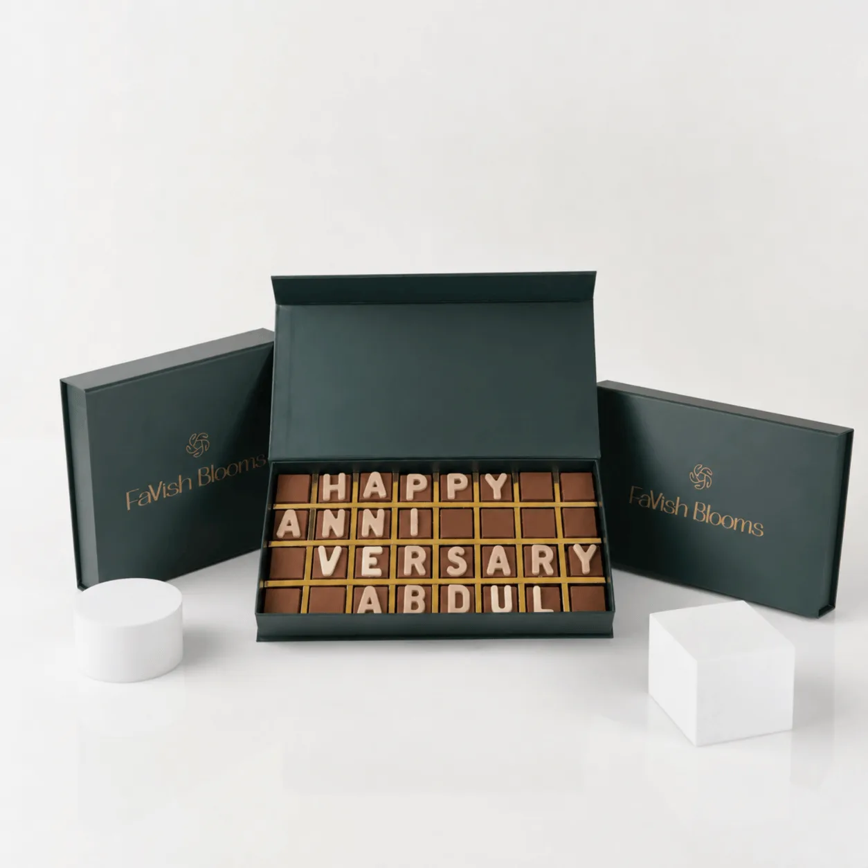 "Chocolate letter box spelling 'Happy Anniversary Abdul' in a green FaVish Blooms gift box."