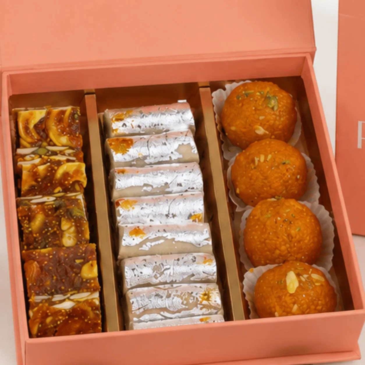 Premium Rakhi Sweets & Ganesha Gift Box beautifully arranged with traditional mithai, Rakhi, roli chawal, and elegant festive packaging