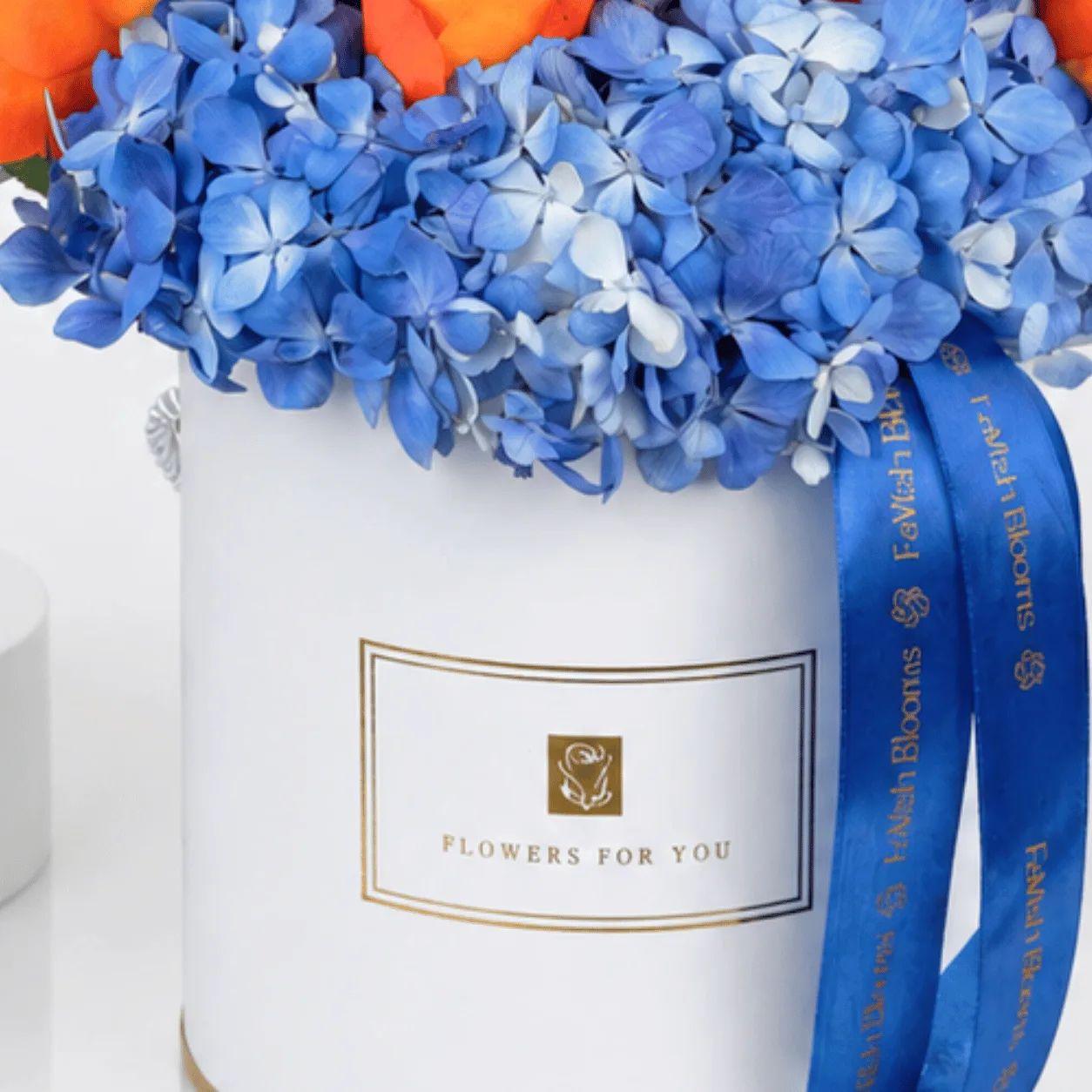 Close-up of white "Flowers For You" box with blue hydrangea