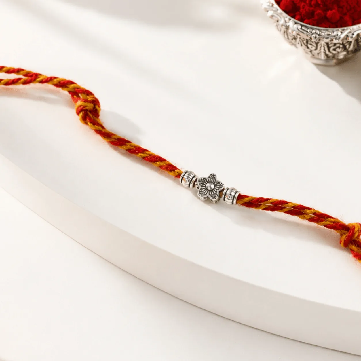 Silver Floral Bead Rakhi with intricate flower design and decorative beads